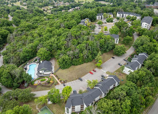 A bird's eye view of a residential area with houses and a swimming pool.