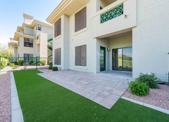 a patio in front of a building with green grass