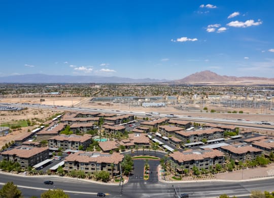 an aerial view of a neighborhood with a road and mountains in the background