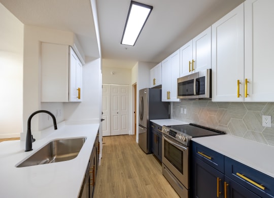 a kitchen with white countertops and blue cabinets