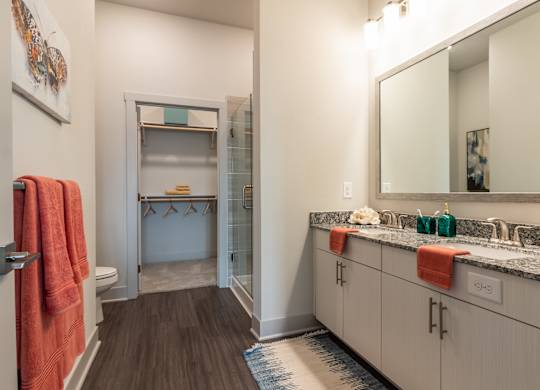 A bathroom with a sink, mirror, and towel rack.