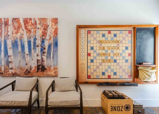a room with two chairs and a scrabble board on the wall