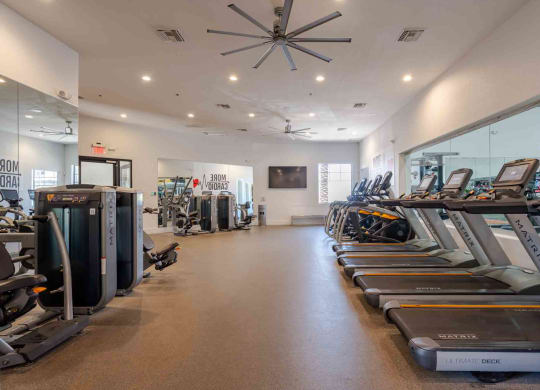 a spacious fitness center with cardio machines and other exercise equipment