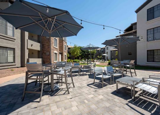 patio with tables and chairs and umbrellas at the residences at silver hill in suitland