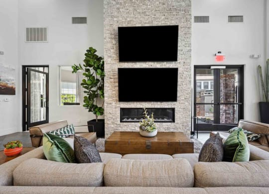 a living room with couches and a coffee table in front of a fireplace