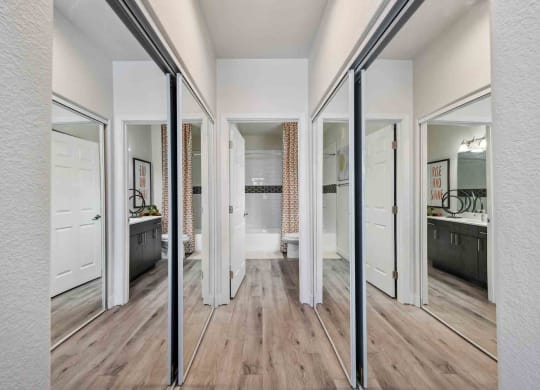 a spacious master bathroom with a hardwood flooring and white walls and ceiling. the room