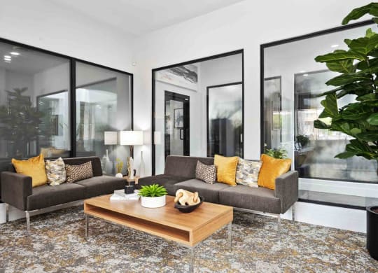 a living room with gray couches and a wooden coffee table on top of a rug