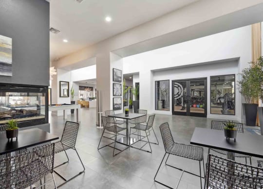 a room with tables and chairs and a fireplace