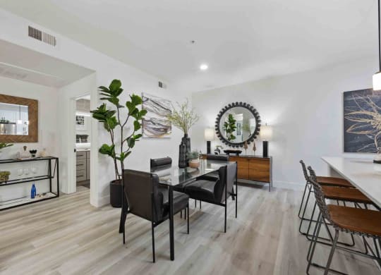 a formal dining room with a glass top dining table and black chairs