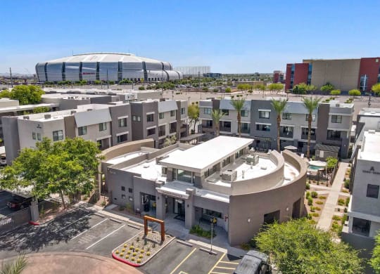 an aerial view of an apartment complex with a soccer stadium in the background