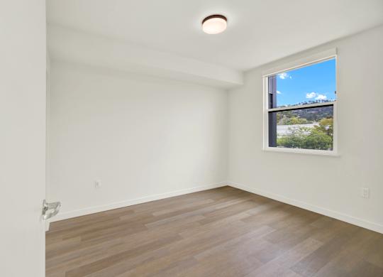A room with a window and a wooden floor at 26FIFTY Apartments, Berkeley, CA, 94704