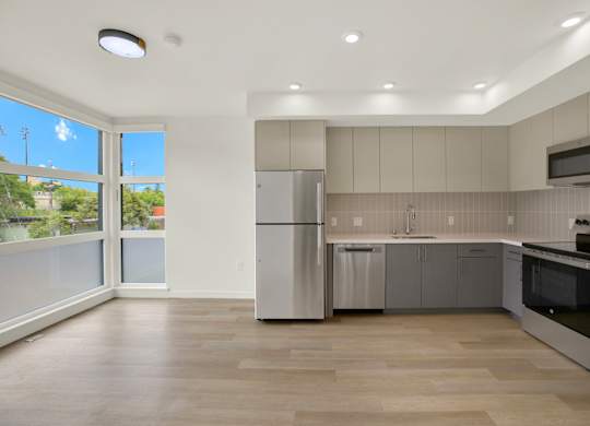 A modern kitchen with stainless steel appliances and wooden flooring at 26FIFTY Apartments, California, 94704