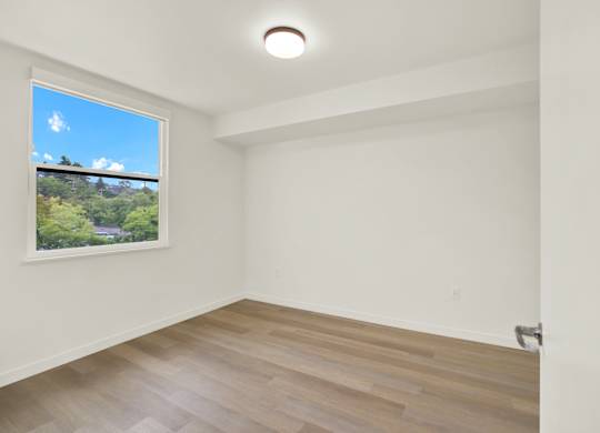 A room with a window overlooking a green landscape at 26FIFTY Apartments, California