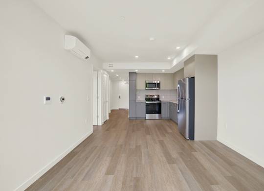 A modern kitchen with a refrigerator, oven, and sink at 26FIFTY Apartments, Berkeley, CA, 94704