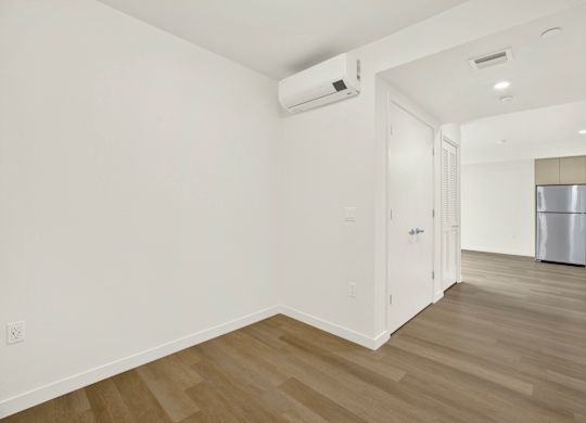 A room with a white wall and a wooden floor at 26FIFTY Apartments, California, 94704