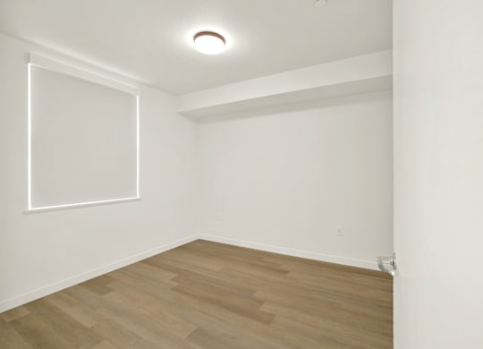 A room with a white wall and a wooden floor at 26FIFTY Apartments, Berkeley