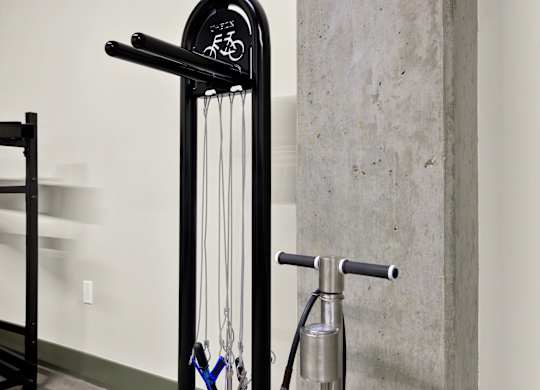 A black bike rack with a bike hanging on it at 26FIFTY Apartments, Berkeley 94704