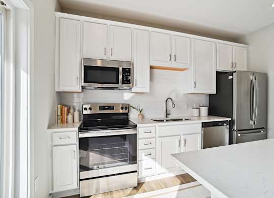 A kitchen with white cabinets and appliances. at Zora University, Charlotte, 28213