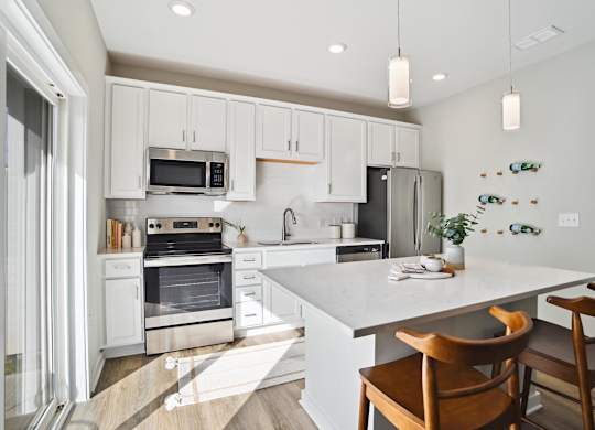 A kitchen with white cabinets and a white island with a wooden chair. at Zora University, Charlotte, NC, 28213