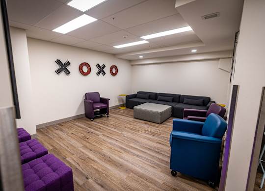 a room with couches and chairs and on the wall