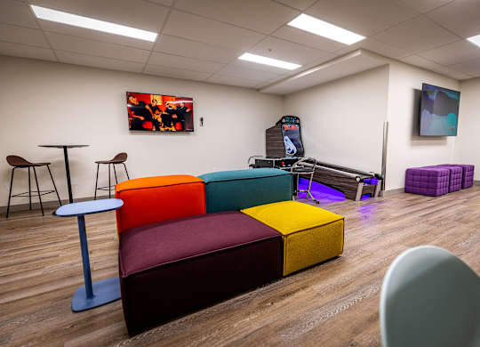 a living room with couches and chairs and a video game on a table
