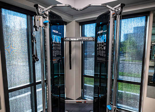 a fitness room with cardio machines and a window