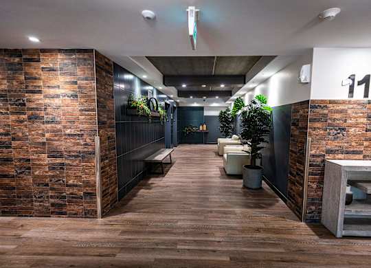 a view of a hallway with wooden floors and brick walls