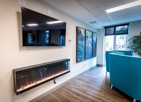 a living room with a fireplace and a tv on the wall