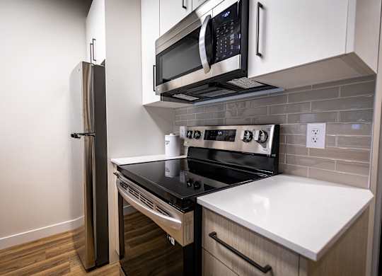 a kitchen with a stove and a microwave and a refrigerator