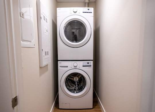a white washer and dryer in a narrow laundry room
