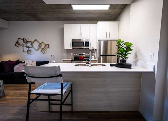 a kitchen with a counter and a chair in a living room