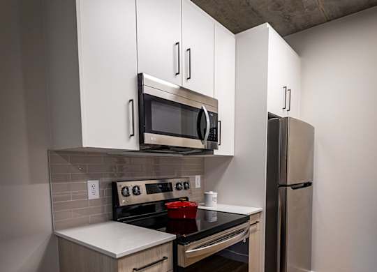 a kitchen with white cabinets and a stainless steel refrigerator