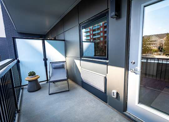 a balcony with a table and a chair and a door