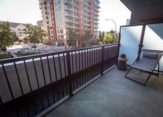 a chair on a balcony with a city street in the background