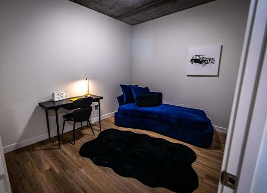 a small room with two couches and a table with a chair