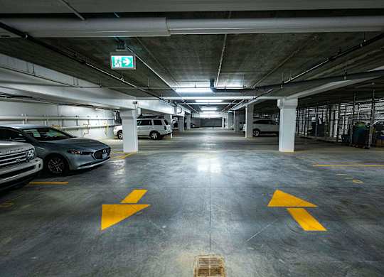 a parking garage with cars and a exit sign