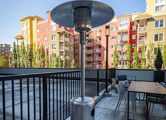 a heater on a rooftop patio with tables and buildings