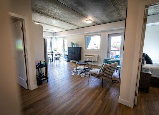 an open living room and dining room with a hard wood floor and a grey ceiling