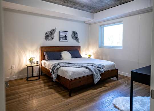 a bedroom with a bed and a grey ceiling and a window