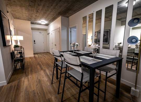 a dining room with a table and chairs and a large mirror