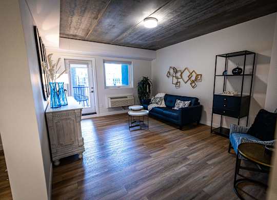 a living room with a wooden floor and a blue couch