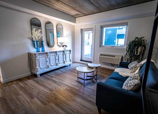 a living room with a black couch and a wooden floor