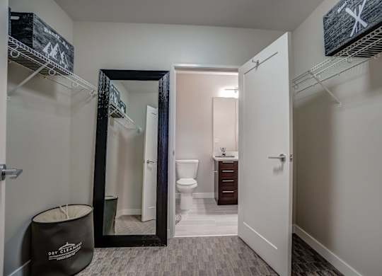A bathroom with a toilet, sink, and mirror.