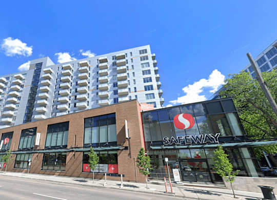 A Safeway store is located in front of a tall building.