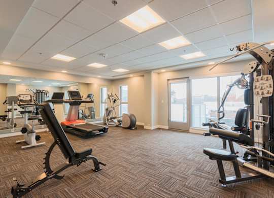 A spacious gym with a variety of equipment including treadmills, weights, and exercise machines.