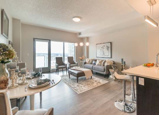 A well-lit, modern living room with a dining table set for two.