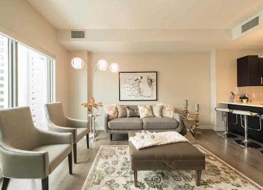 A living room with a grey couch, a coffee table, and a painting on the wall.