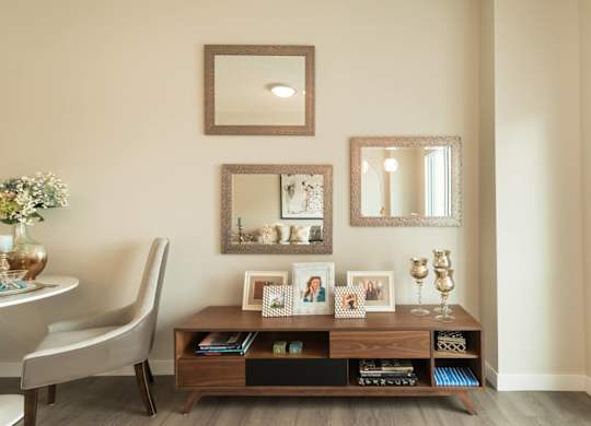A living room with a chair, a table, and a mirror.