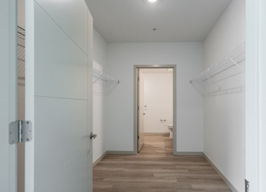 a hallway with white walls and a wooden floor