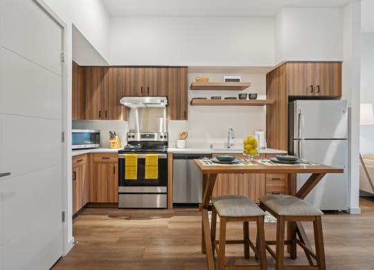 a kitchen with wooden cabinets and a table with two stools